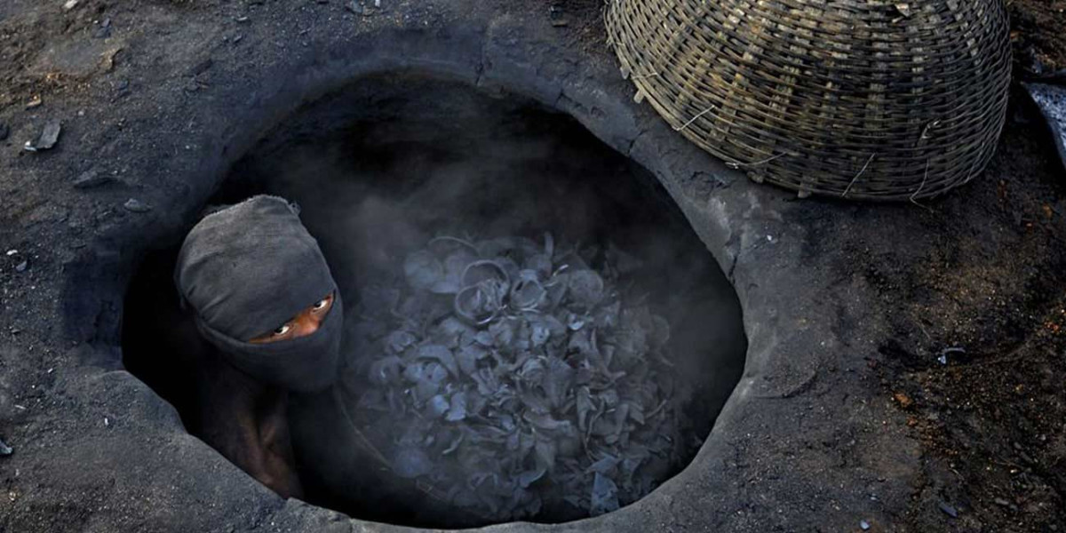 Черный уголь в яме и человек в черной маске